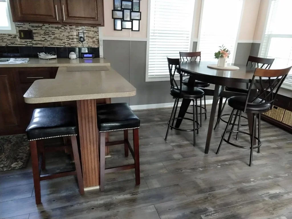 Modern kitchen with breakfast bar and dining area inside the Crimson Poppy tiny home in Flat Rock, NC.