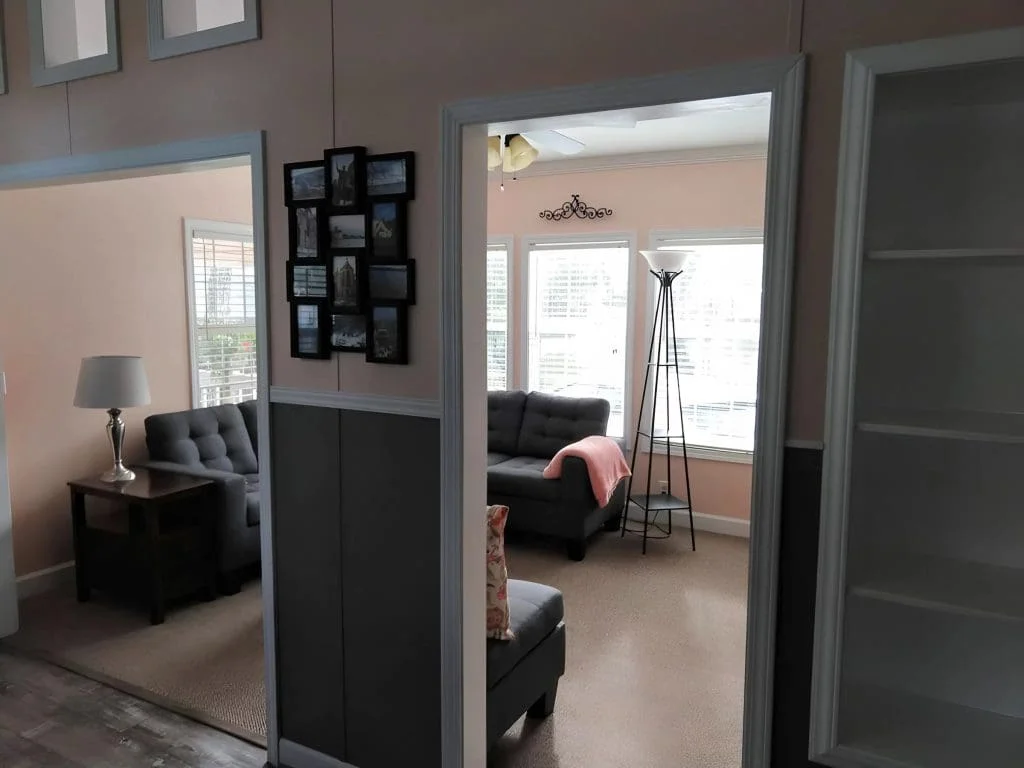 Interior view showing the open layout connecting the living room and kitchen inside the Crimson Poppy tiny home.