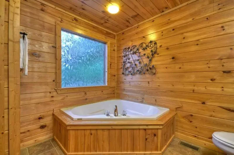Private bathroom with a jetted bathtub and natural wood walls