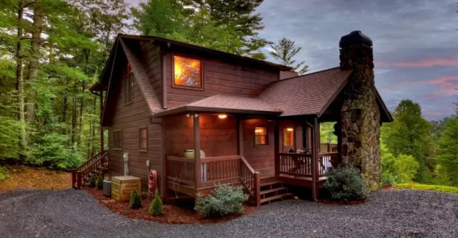 Front view of Mountain High Lodge with a covered porch and stone chimney